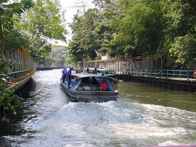 2 barcos que pasan cerca de Klong Saphan Hua Chang. Obsérvense los conductores de pie a cada lado de la embarcación. Los cascos son para protegerlos de estructuras elevadas, tales como puentes